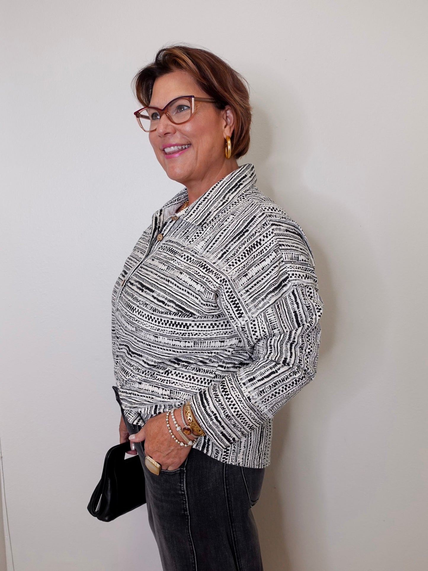 Woman wearing a patterned blouse against a plain background