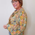 Woman wearing a patterned jacket against a plain background