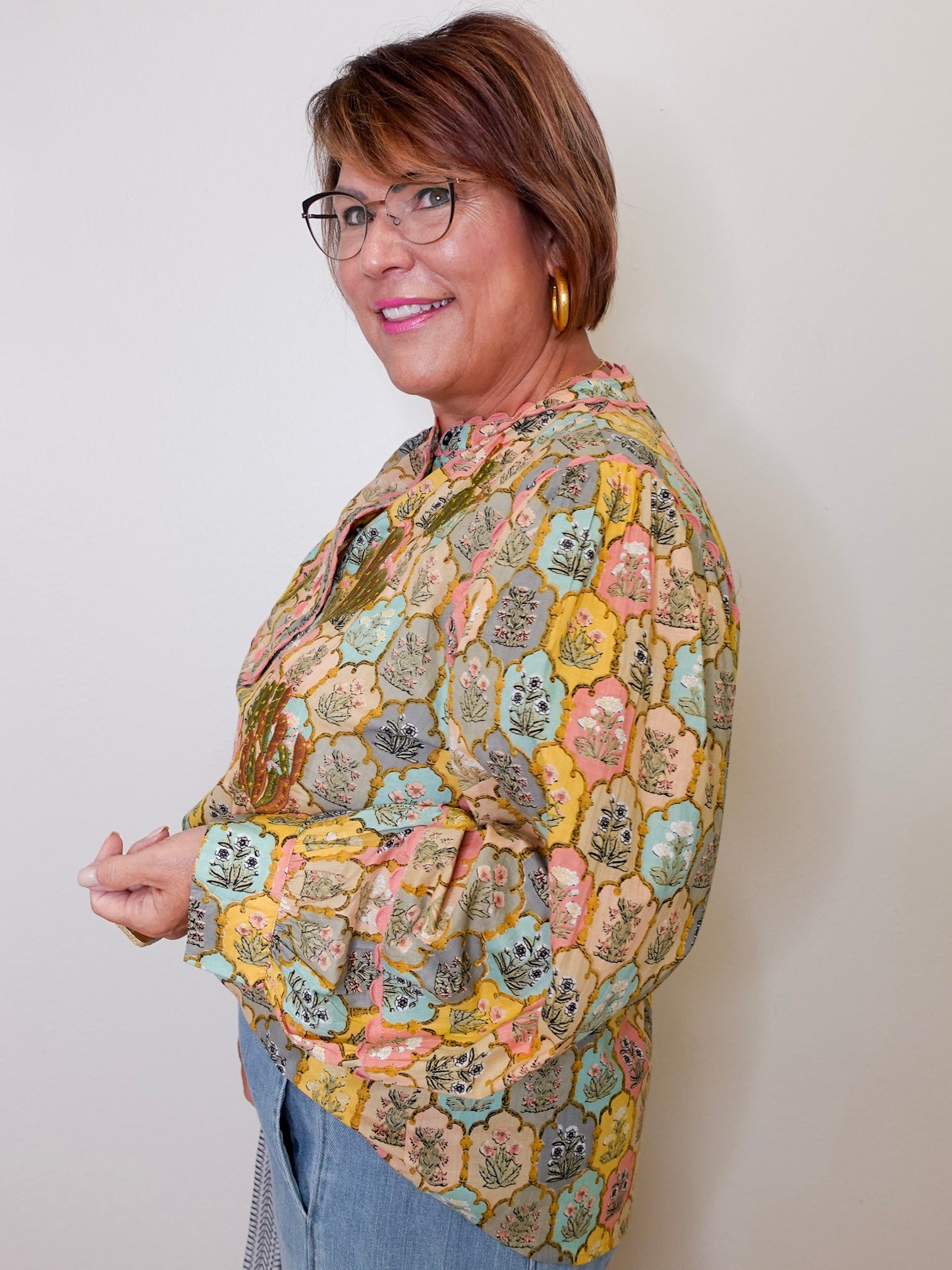 Woman wearing a patterned jacket against a plain background