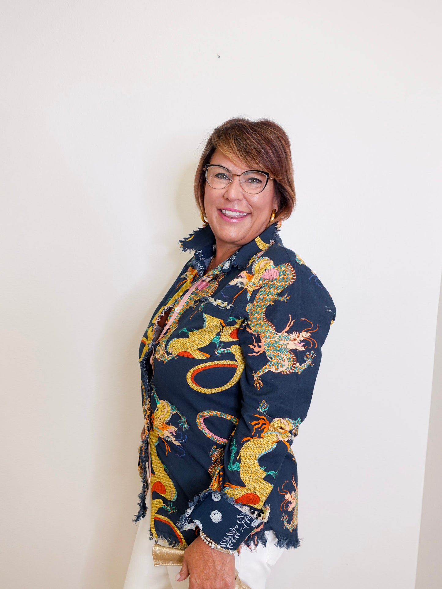 Woman wearing a colorful dragon patterned shawl against a white background
