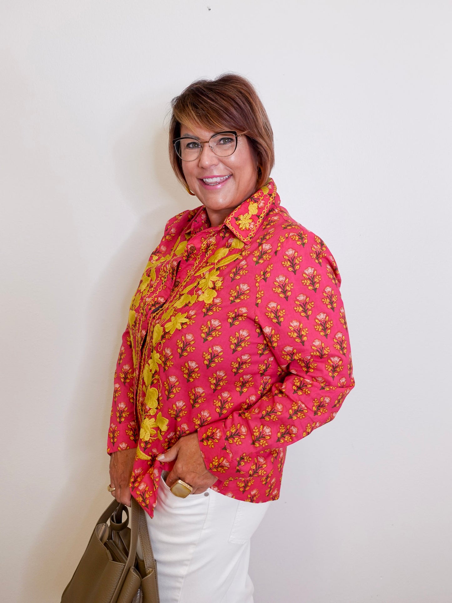 Woman wearing a pink floral top against a white background