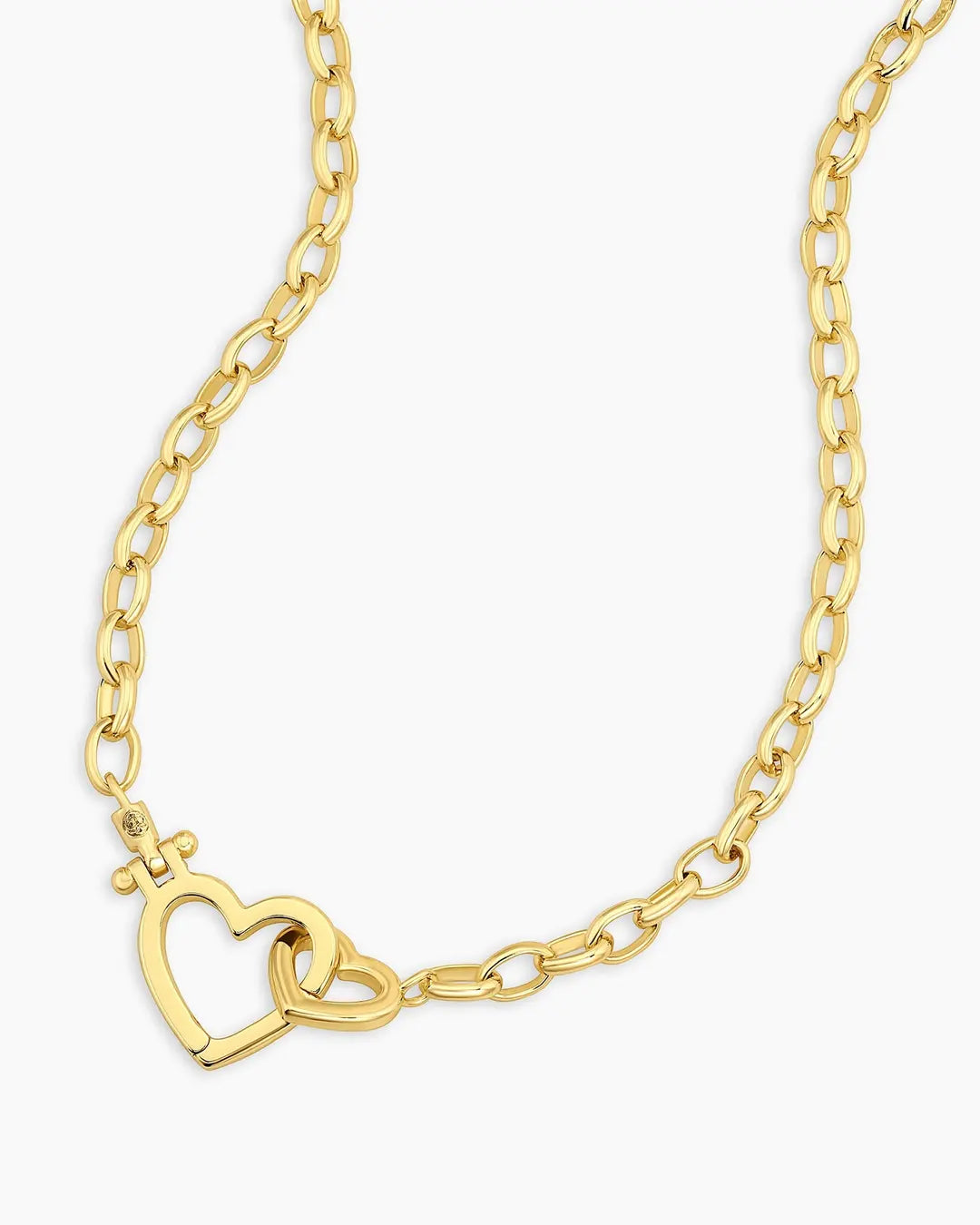Gold chain necklace with a heart design on a white background