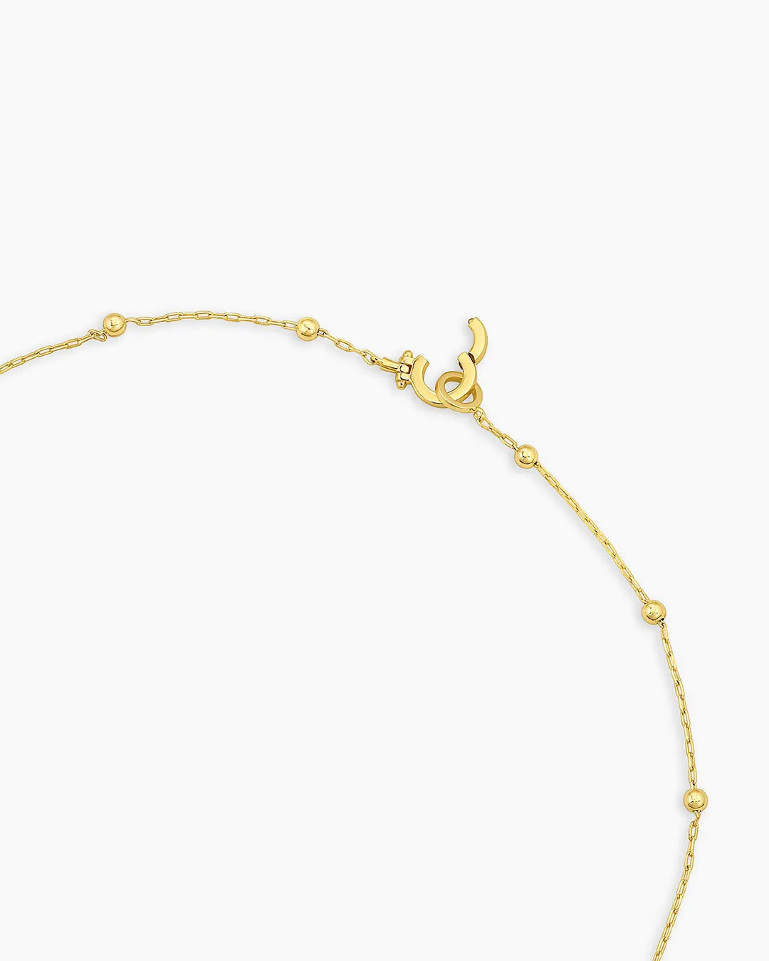 Gold bracelet with a heart charm on a white background