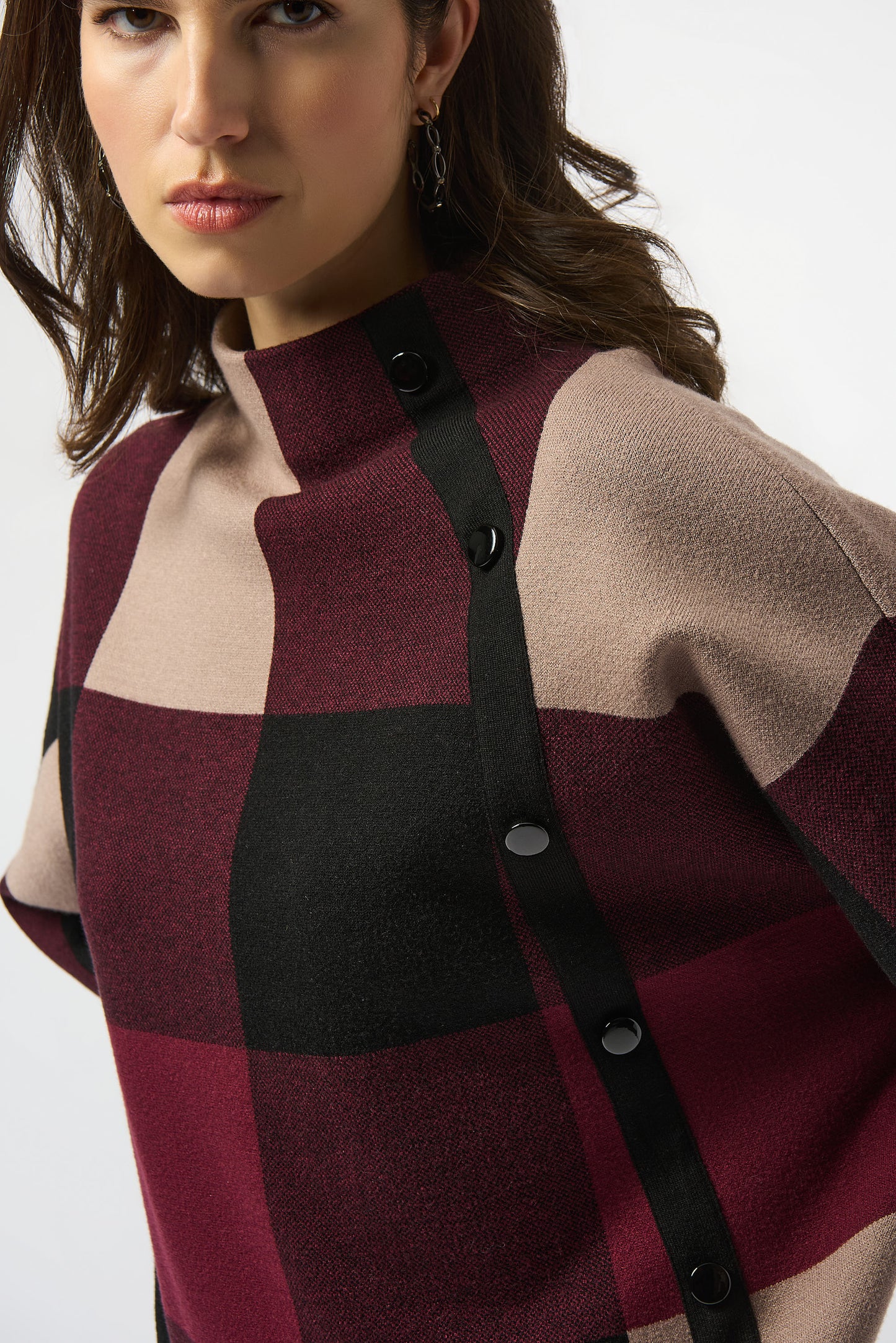 Close-up of a person wearing a checkered coat with a white background
