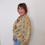 Woman wearing a colorful patterned shawl against a white background