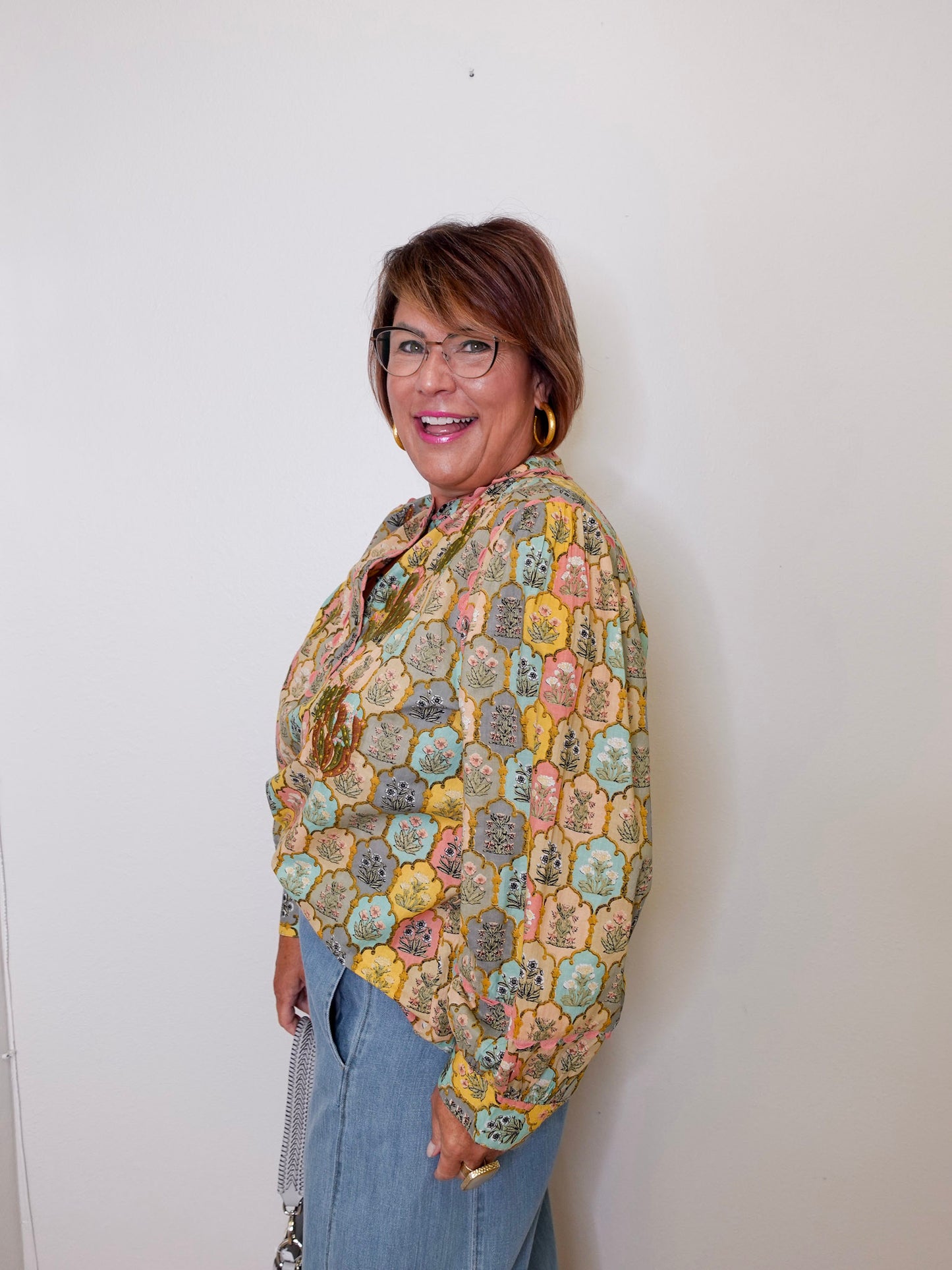 Woman wearing a colorful patterned shawl against a white background