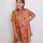 Woman wearing a patterned dress with a plain background