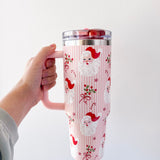 Tumbler with Santa Claus design held by a hand against a white background