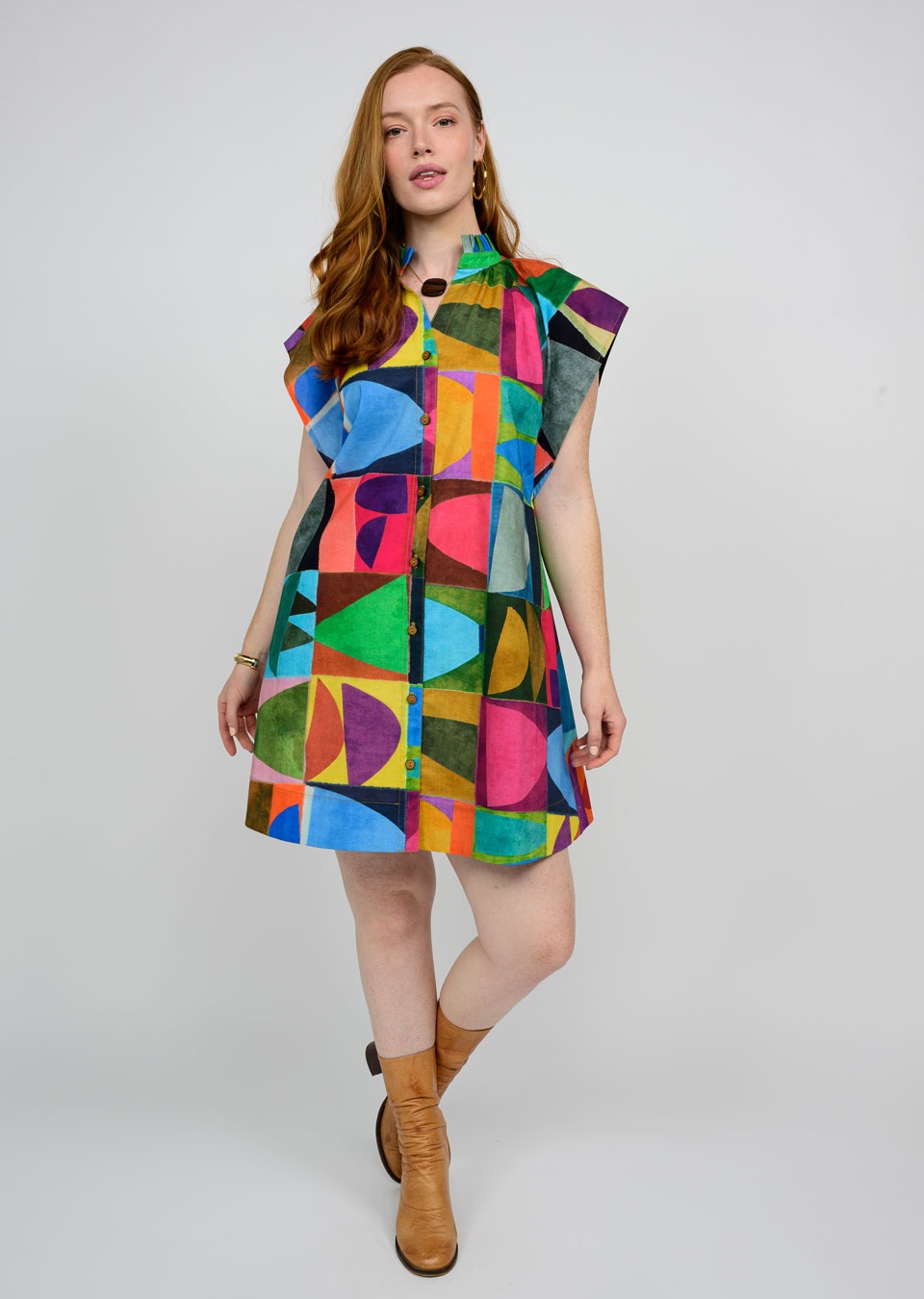 Woman wearing a colorful geometric patterned dress on a white background