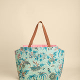Floral-patterned tote bag with brown handles on a beige background