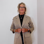 Person wearing a plaid blazer against a plain background