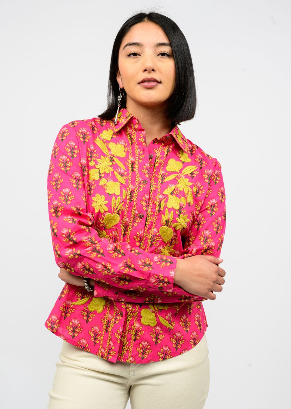 Woman wearing a pink floral blouse against a white background