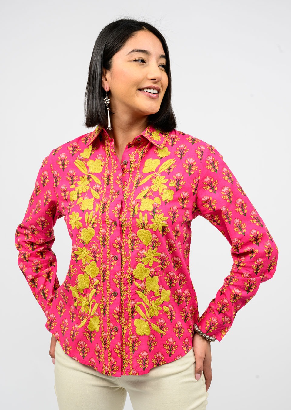 Woman wearing a pink floral shirt against a white background