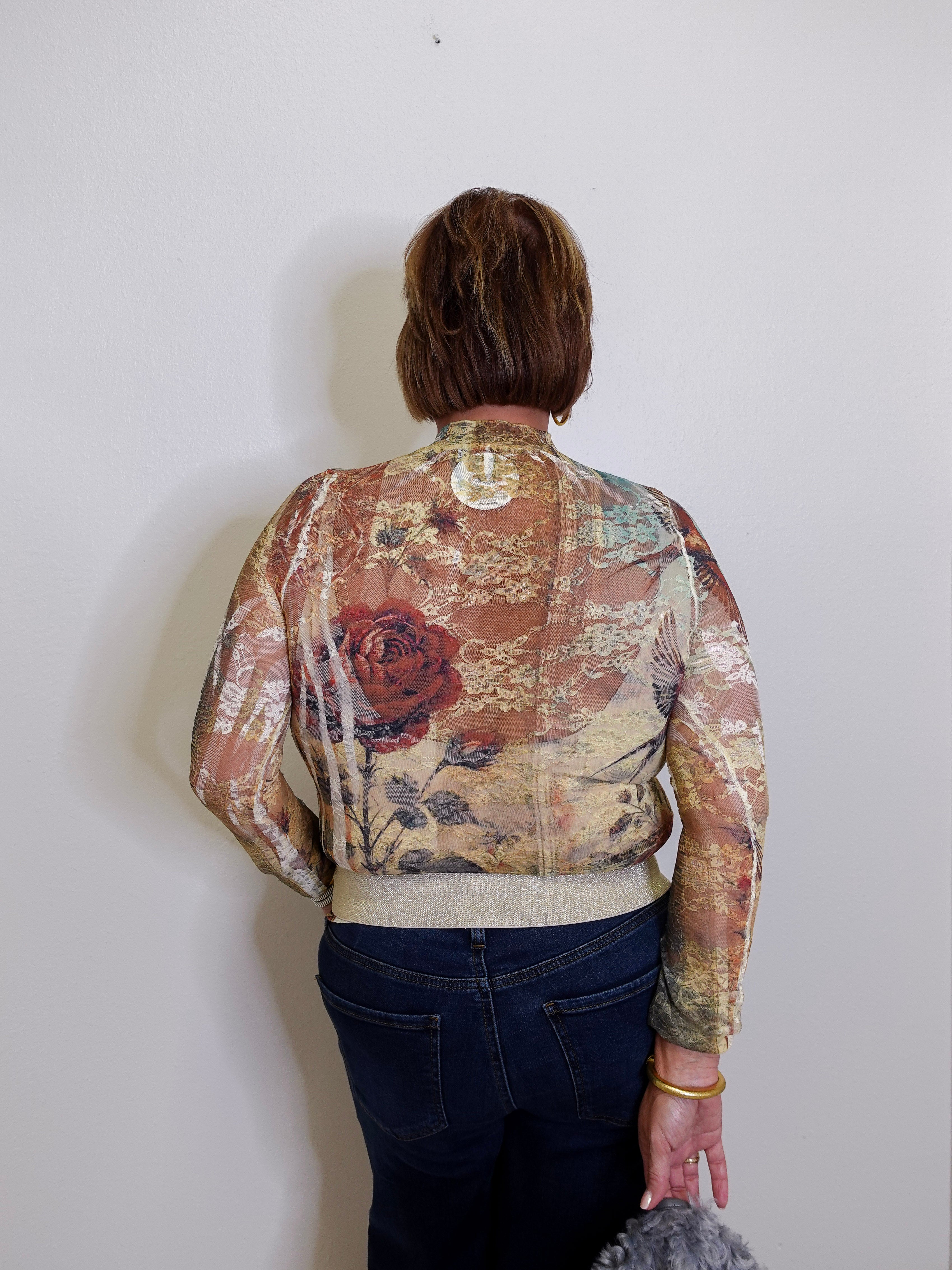 Person wearing a floral-patterned jacket against a plain background