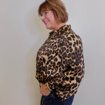 Woman wearing a leopard print shirt against a plain background
