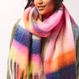 Person wearing a colorful striped scarf on a white background