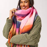 Woman wearing a colorful scarf and green jacket on a white background