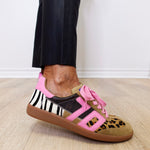 Shoes with zebra print and leopard pattern on a wooden floor