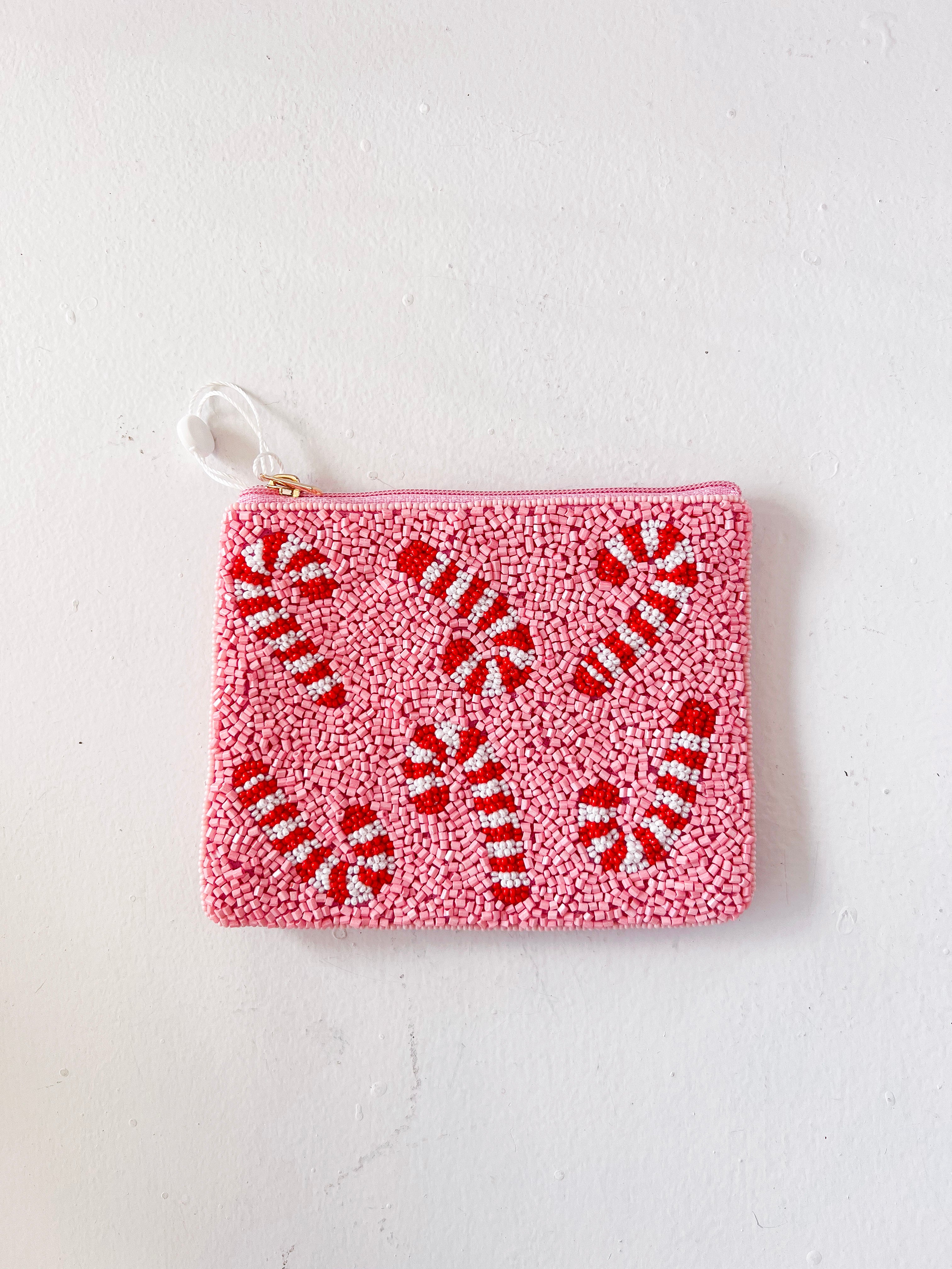 Pink pouch with red candy cane pattern on a white background
