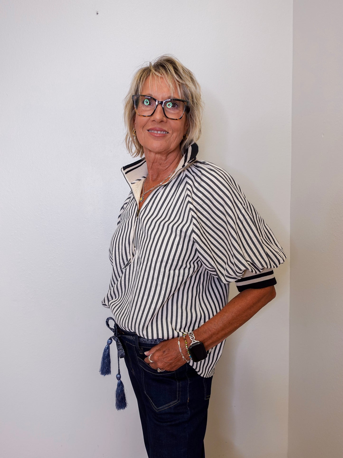 Woman wearing a black and white striped shirt with a plain background