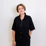 Woman wearing a black dress with a zipper against a white background
