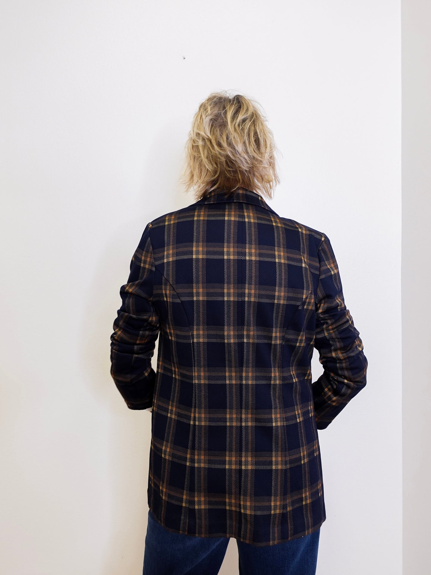 Person wearing a plaid jacket against a white background