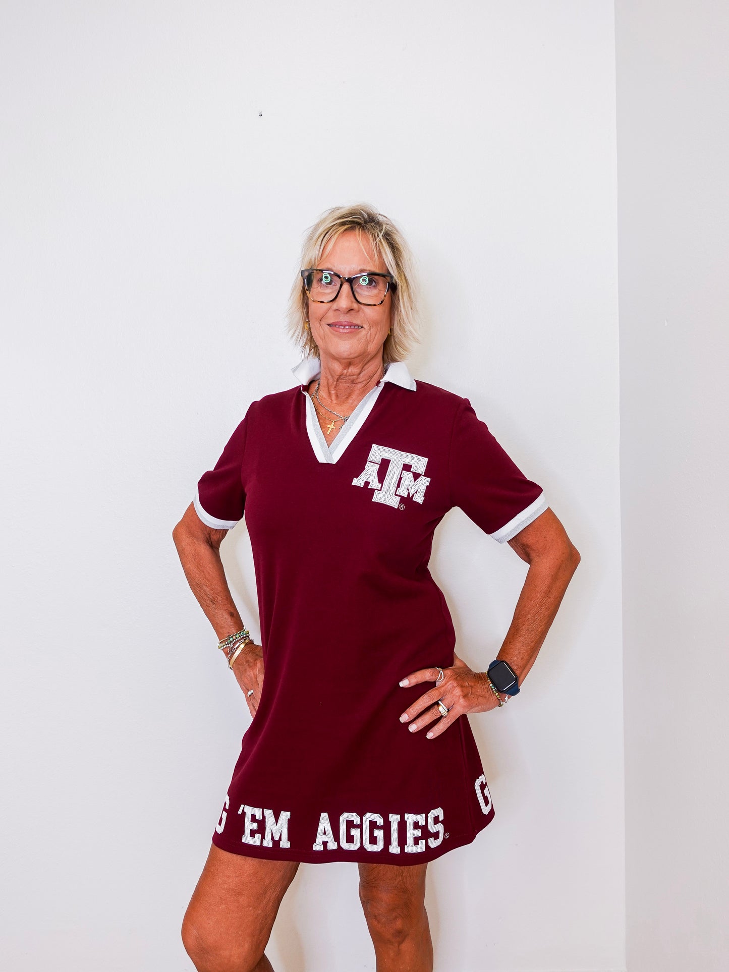 Woman wearing a maroon dress with 'AGGIES' text against a white background