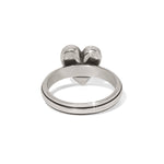 Silver ring with two small ball-like structures on a white background