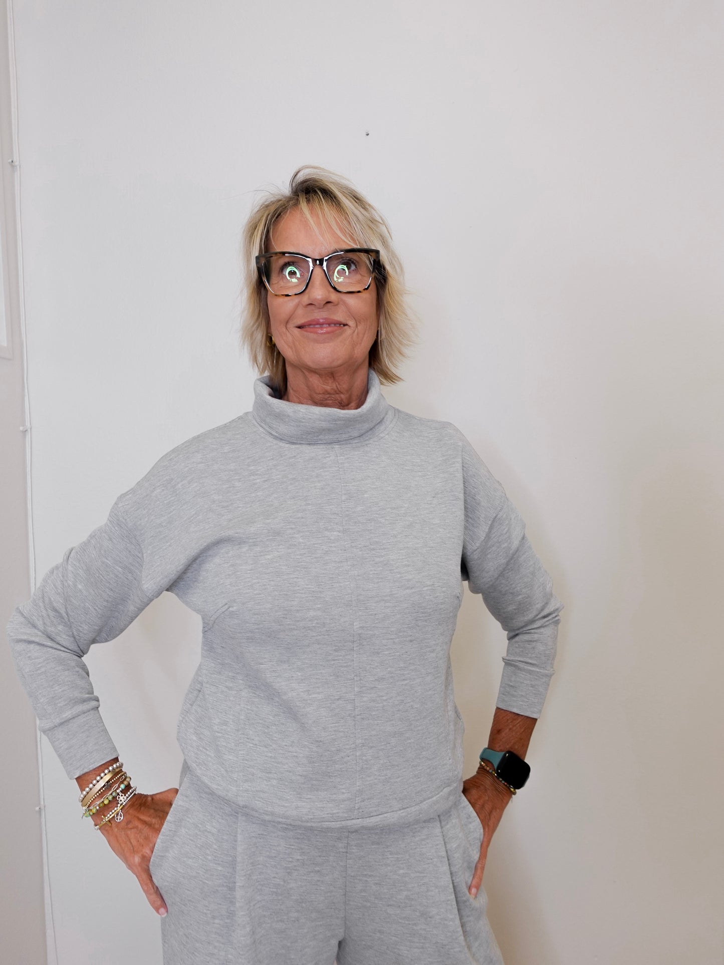 Person wearing a gray outfit against a white background
