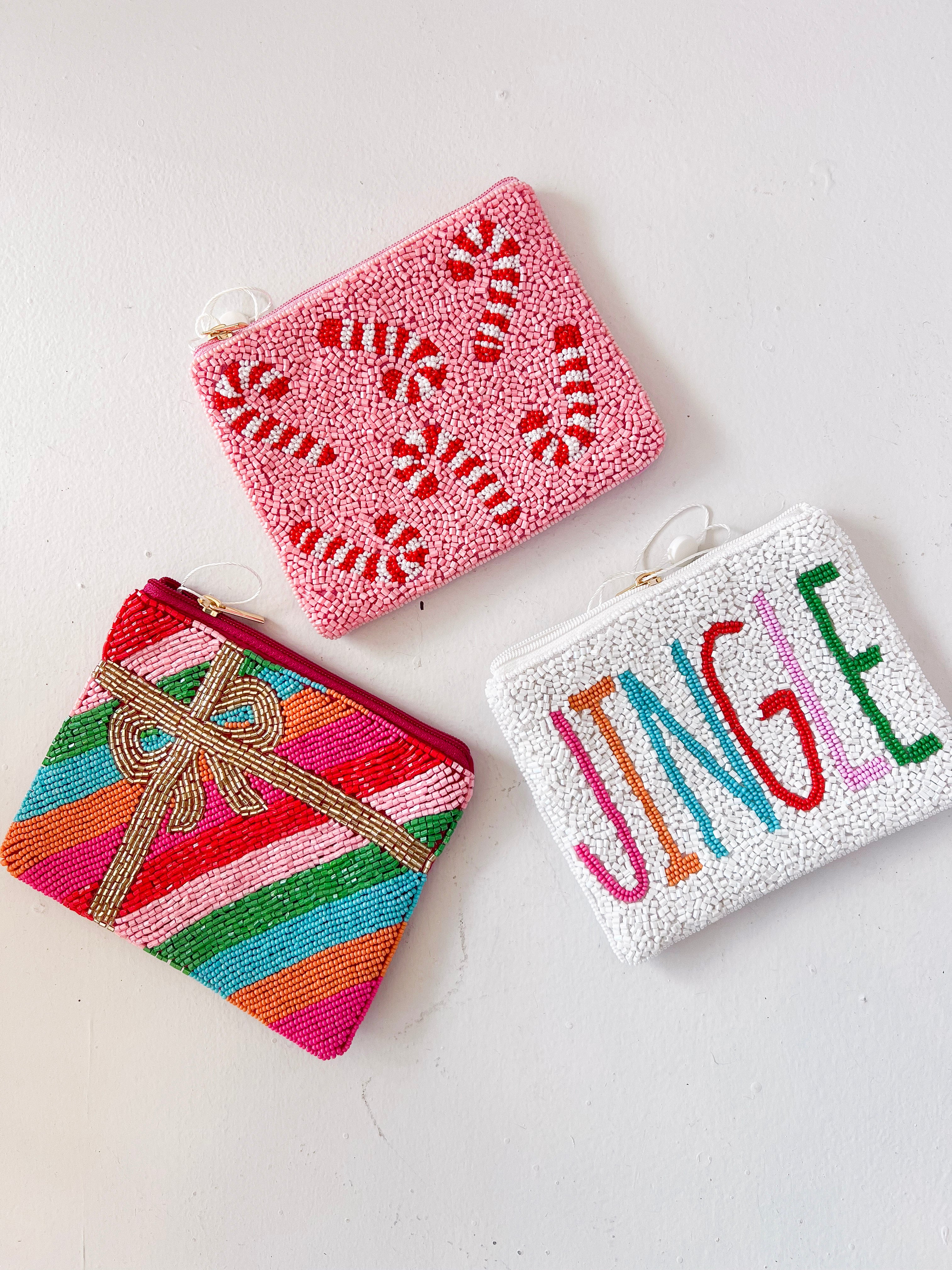Three colorful beaded pouches with different designs on a white background