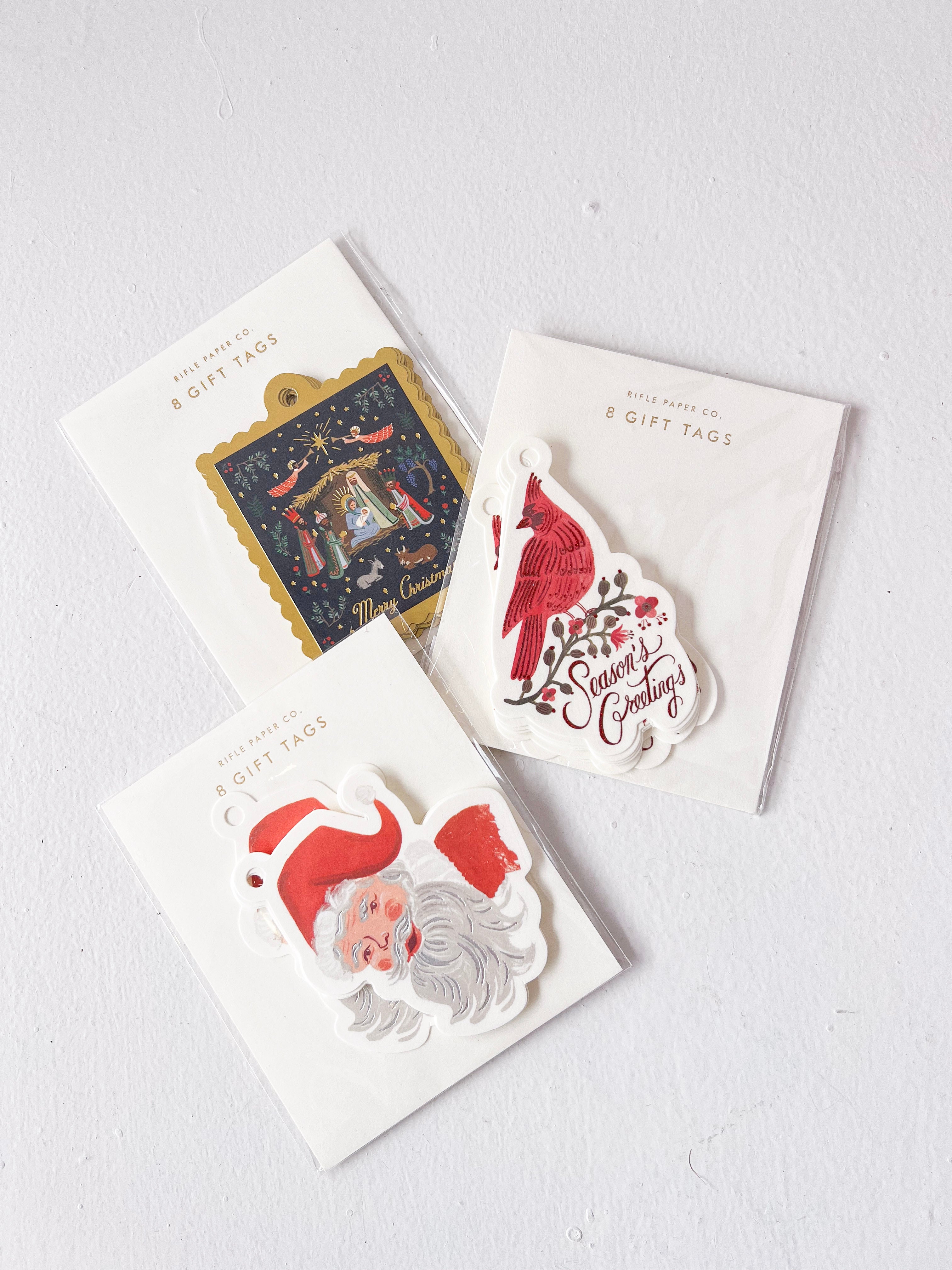 Three packages of Christmas-themed gift tags on a white background