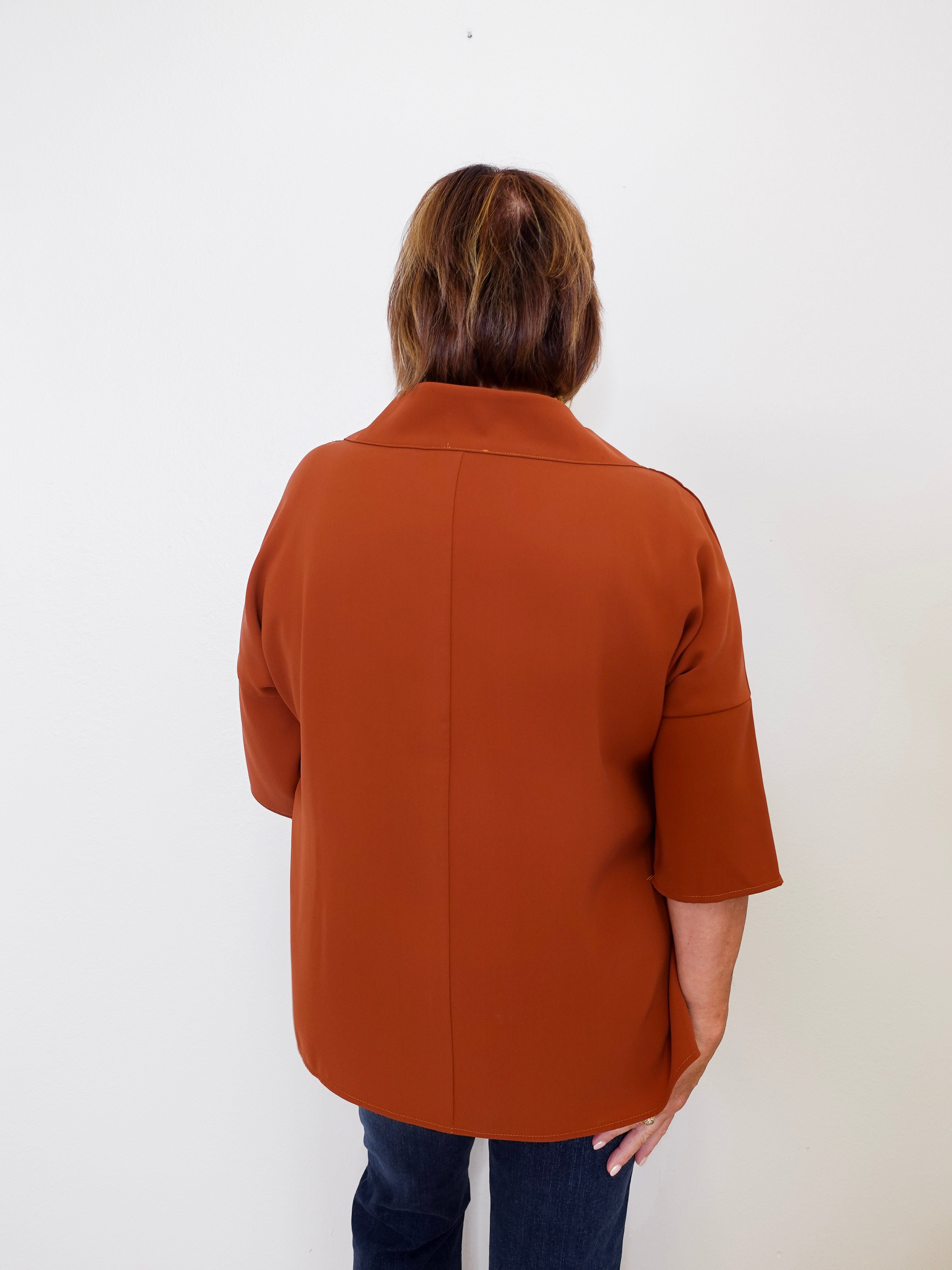 Person wearing a brown coat against a white background