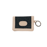 Small beige wallet with a keychain on a black background