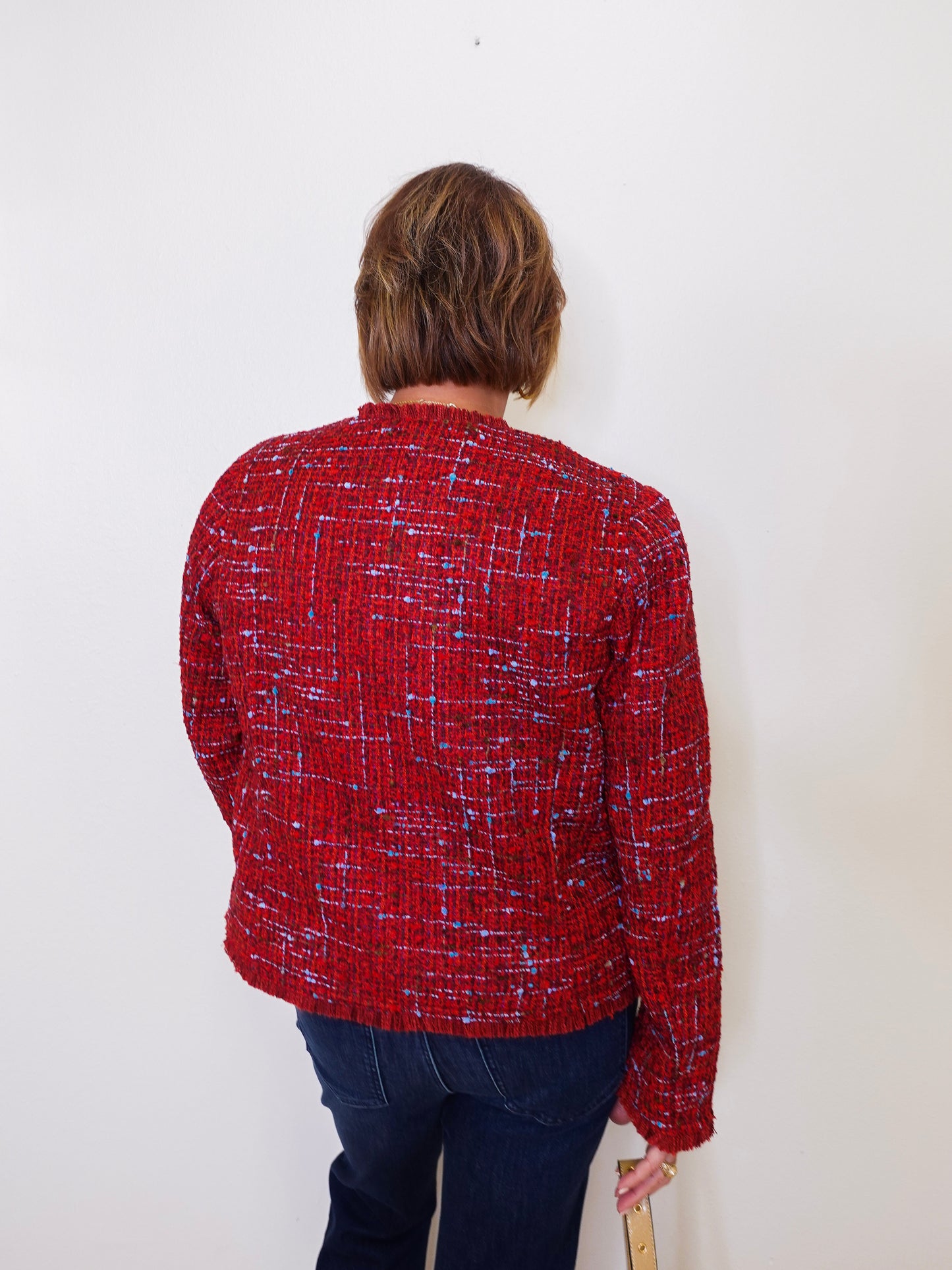 Person wearing a red patterned shirt against a white background