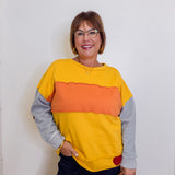 Woman wearing a colorful sweater with a plain background