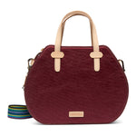 Maroon handbag with beige handles on a white background