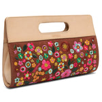 Floral embroidered clutch bag with beige top handle on a white background