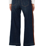 Dark blue jeans with a side stripe worn by a person on a white background