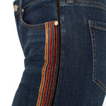 Close-up of dark blue jeans with a striped side pocket on a white background