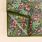 Floral patterned fabric with green leaves and pink flowers on a beige background