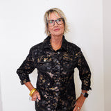 Woman wearing a black floral jacket against a white background