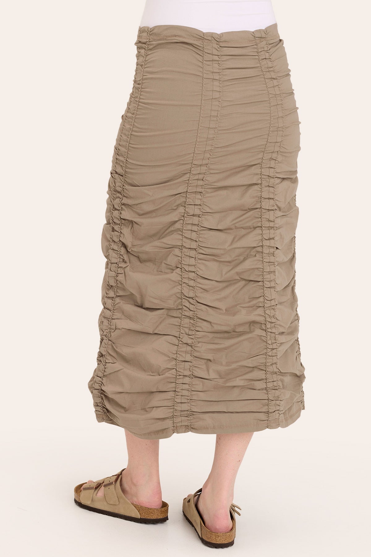 Beige ruched skirt worn by a person on a white background