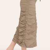 Beige ruched pants worn by a person on a white background