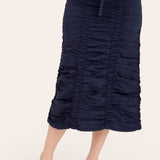Navy blue ruched skirt worn by a person on a white background