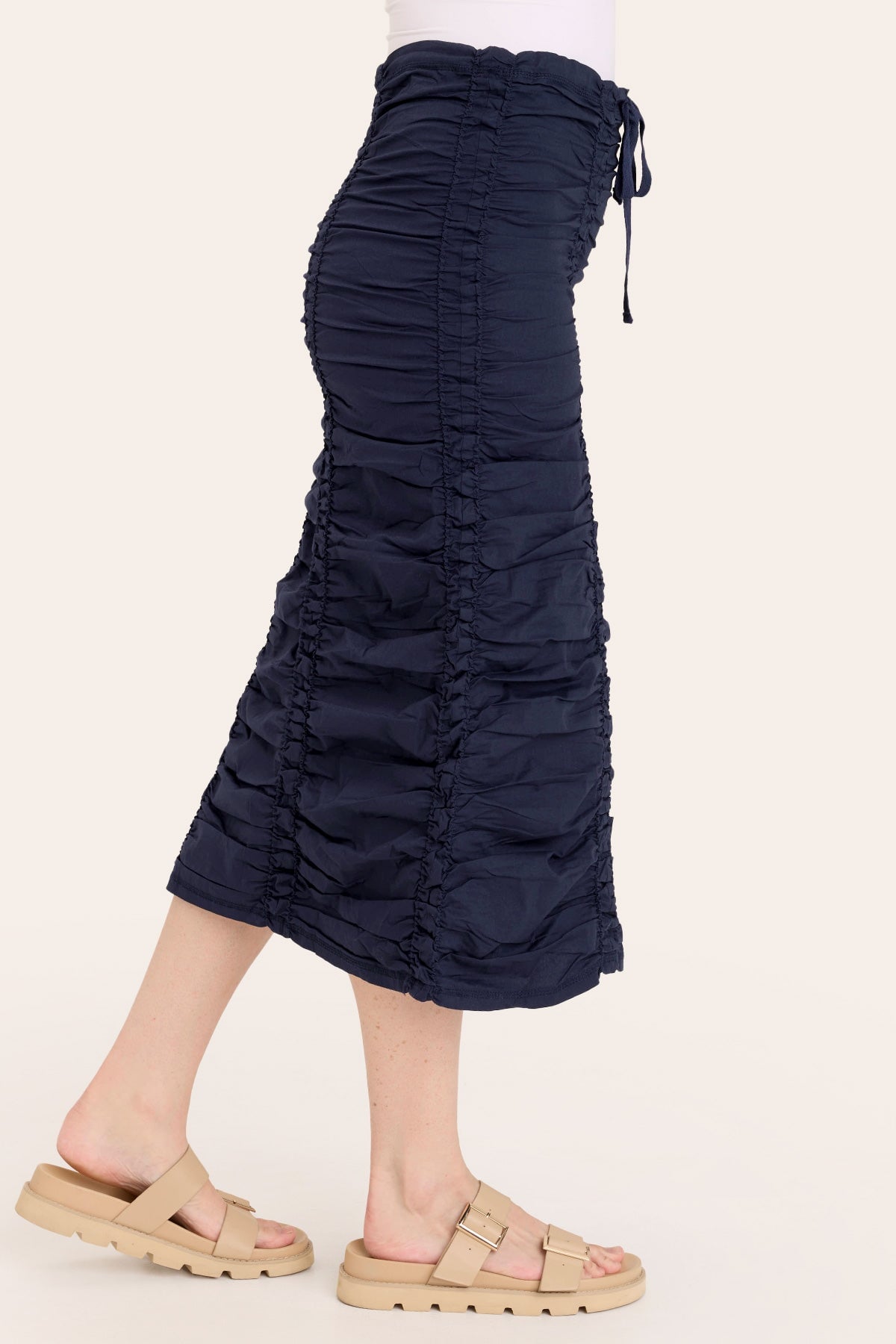Navy blue ruched skirt worn by a person on a white background