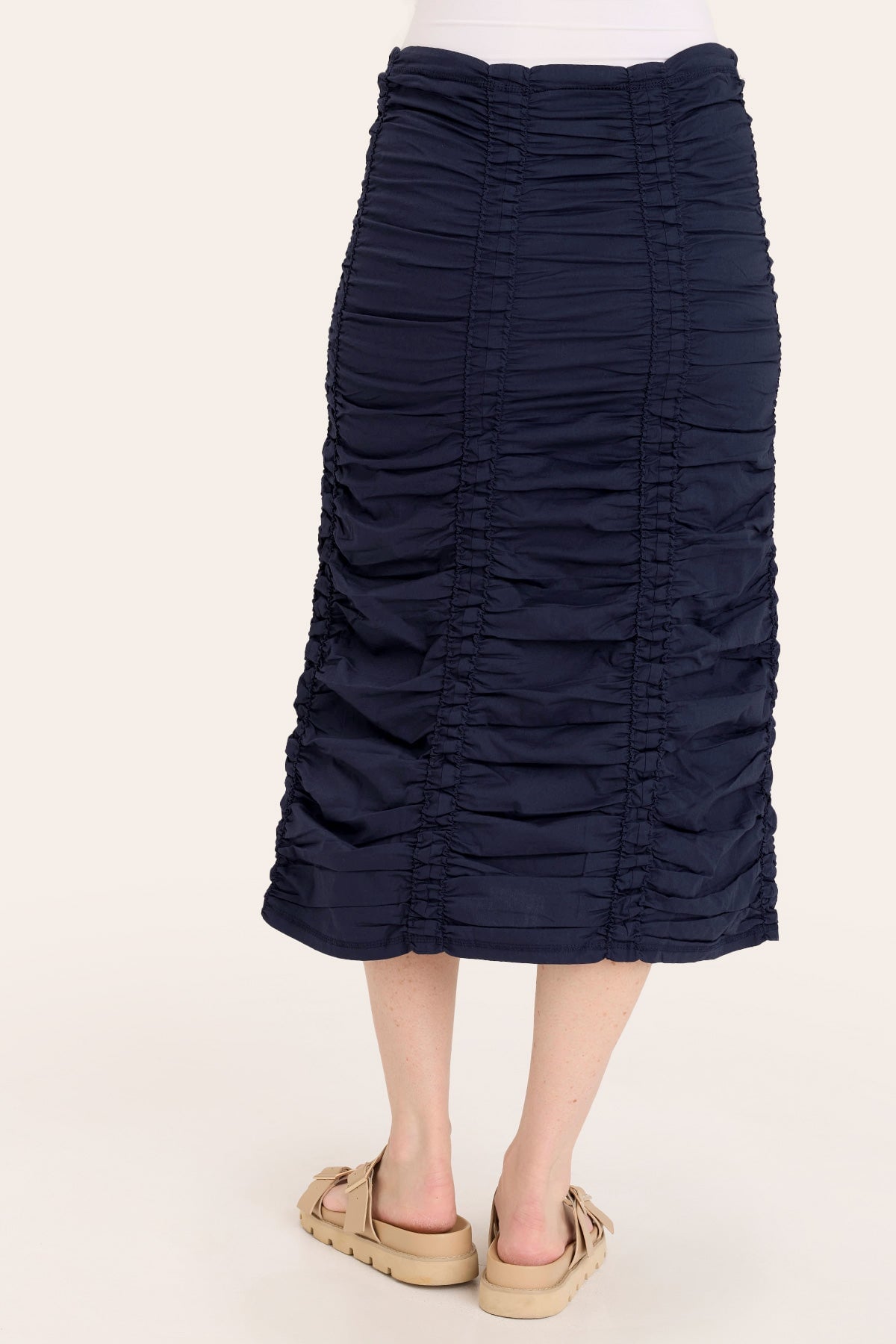 Navy blue ruched skirt worn by a person on a white background