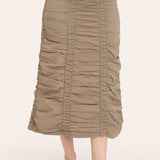 Person wearing a beige ruched skirt on a white background
