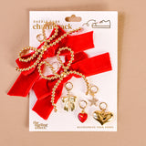Shoe charm pack with gold and red charms on a beige background