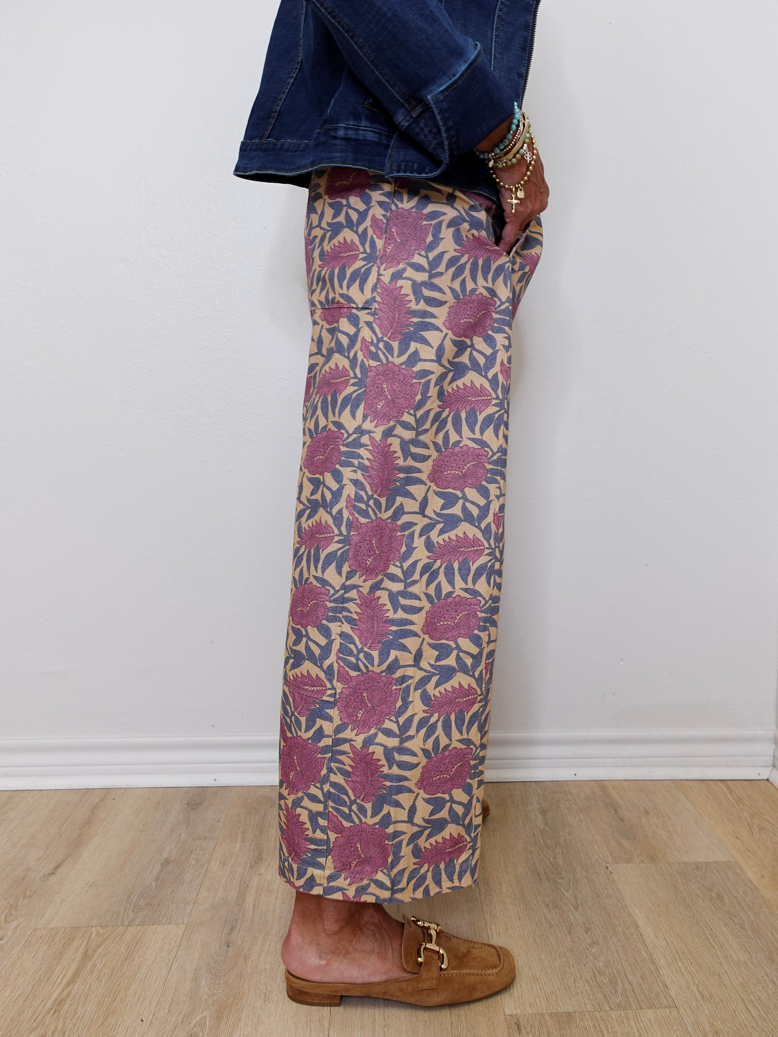 Person wearing a patterned skirt with a plain background