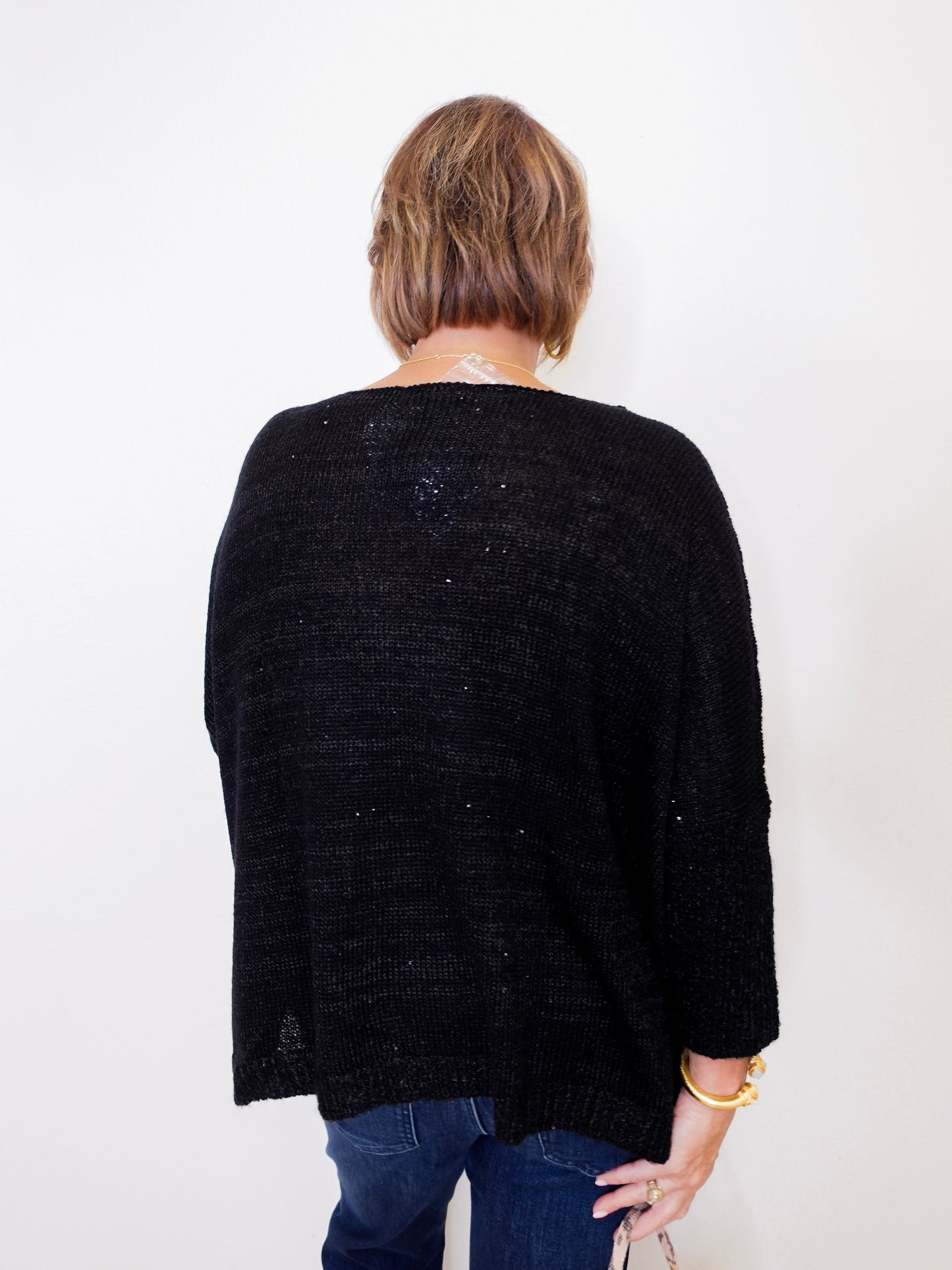 Person wearing a black cardigan against a white background